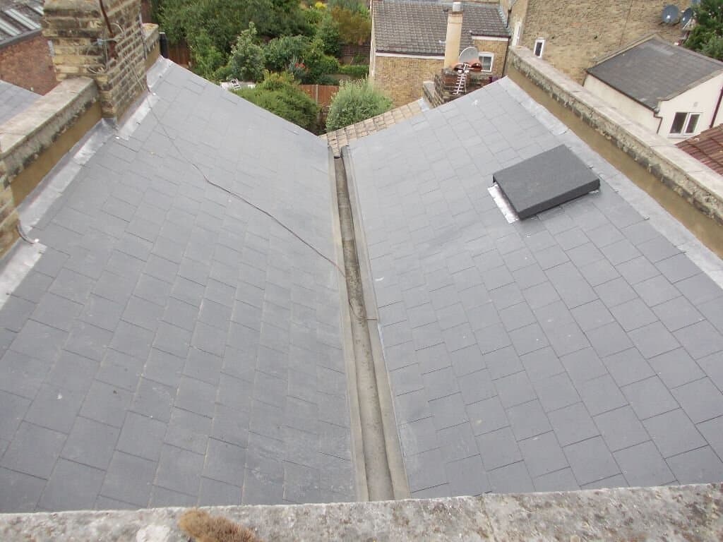 Completed roof surface with chimney and neighboring properties